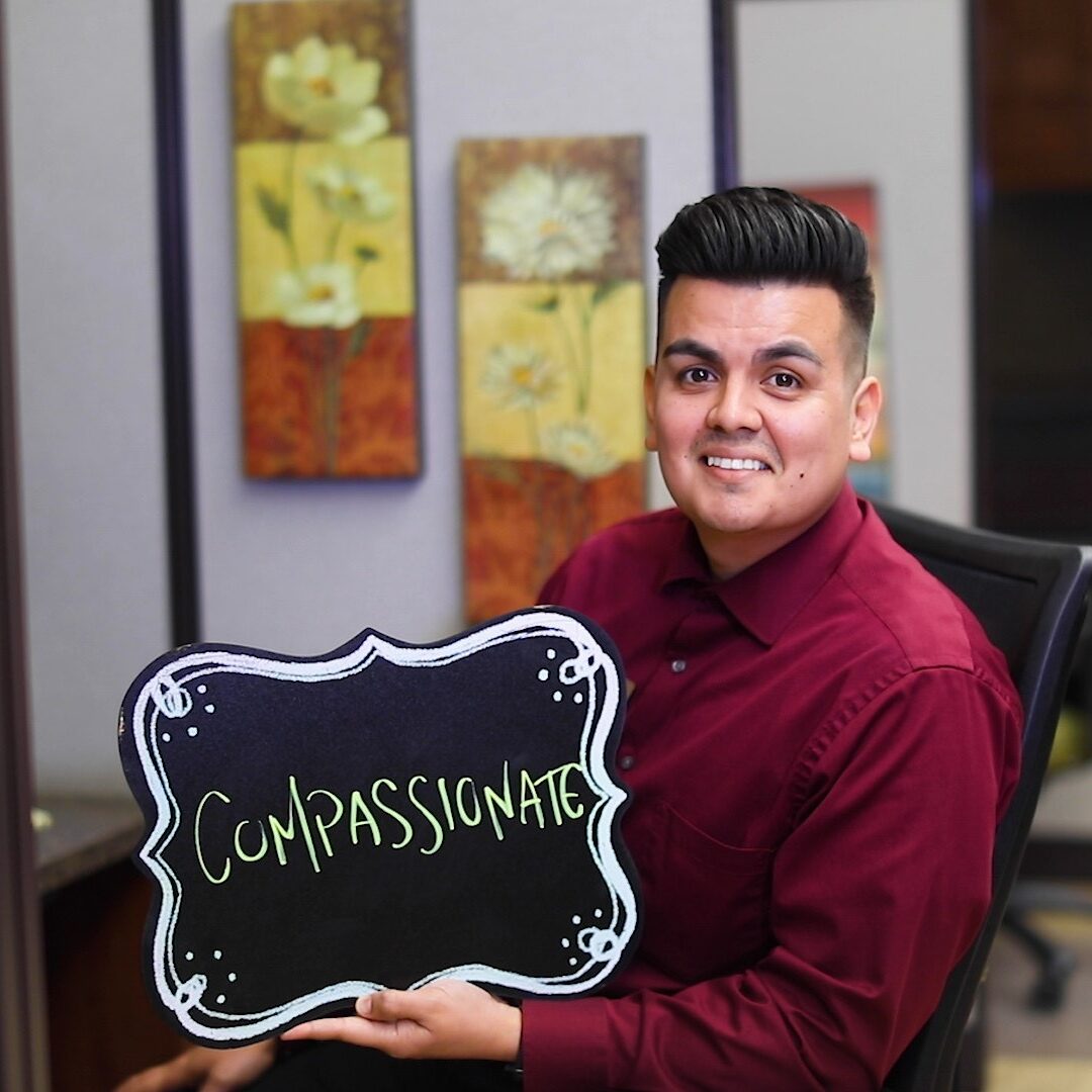 Loan officer Johnny holding a sign that says Compassionates